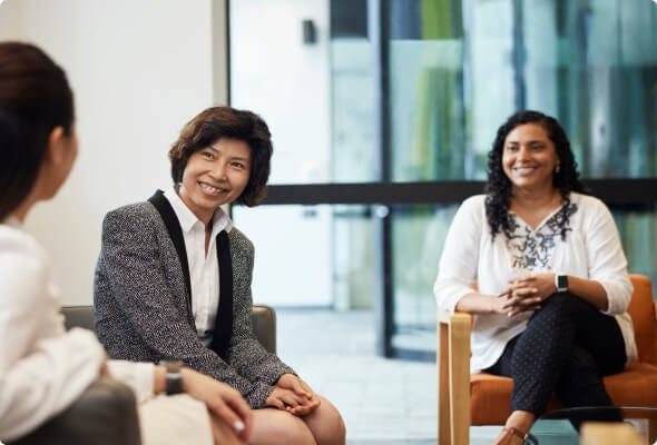 Three senior BlueScope employees sit comfortably and chat 