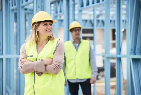 Two site staff in high-visibility clothing standing next to a TrueCore(R) steel structure