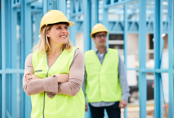 Two site staff in high-visibility clothing standing next to a TrueCore(R) steel structure