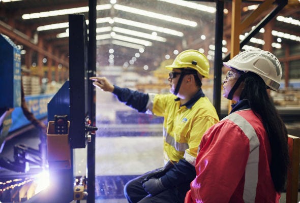 Two BlueScope workers seated in a manufacturing facility