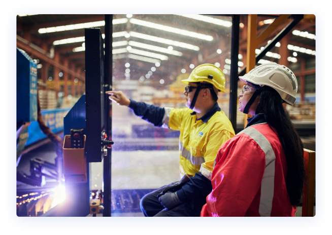 Two workers seated in a manufacturing facility