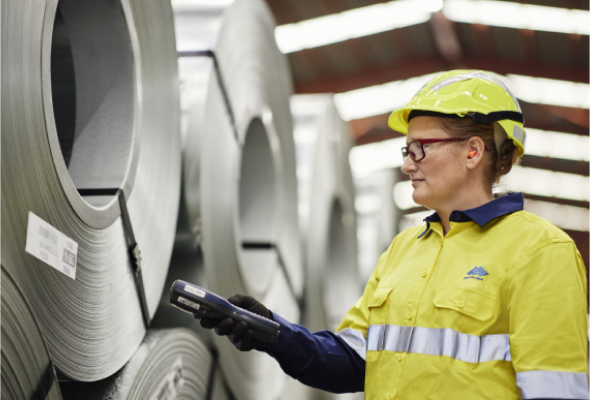 Worker inspecting rolled steel